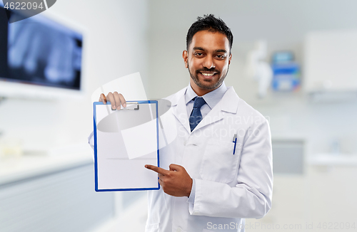 Image of dentist with paper on clipboard at dental clinic