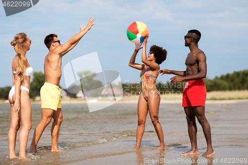 Image of friends playing with beach ball in summer