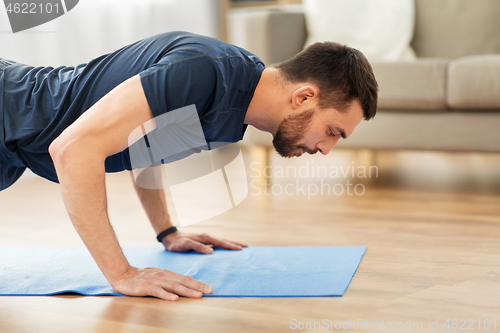 Image of man doing push ups at home