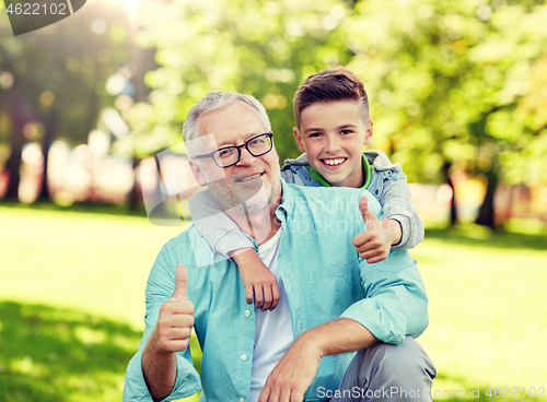 Image of grandfather and boy showing thumbs up at summer