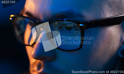 Image of close up of hacker in glasses looking at screen