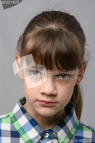 Image of Portrait of a ten-year-old girl with a piercing look, European appearance, close-up