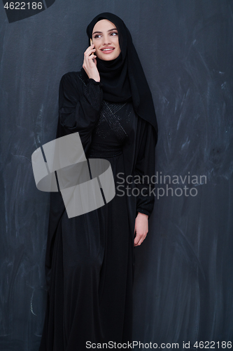 Image of young modern muslim business woman using smartphone