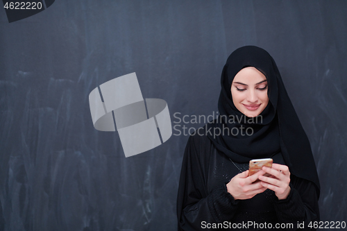 Image of young modern muslim business woman using smartphone