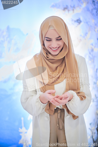 Image of beautiful muslim woman making traditional prayer to God