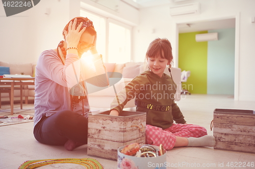 Image of Mother and little girl daughter playing with jewelry  at home