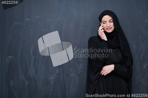 Image of young modern muslim business woman using smartphone