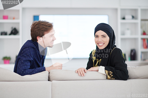 Image of young muslim couple watching TV together