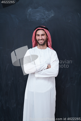 Image of portrait of arabian man in front of black chalkboard