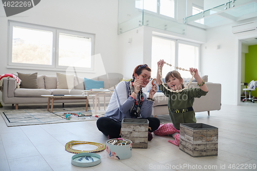 Image of Mother and little girl daughter playing with jewelry  at home