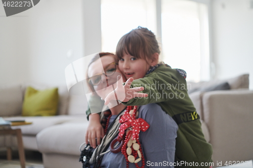 Image of Mother and little girl daughter playing with jewelry  at home