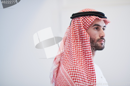 Image of young arabian businessman using smartphone at home