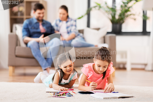 Image of happy sisters drawing in sketchbooks at home