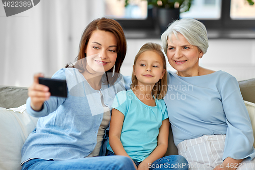 Image of mother, daughter and grandmother taking selfie