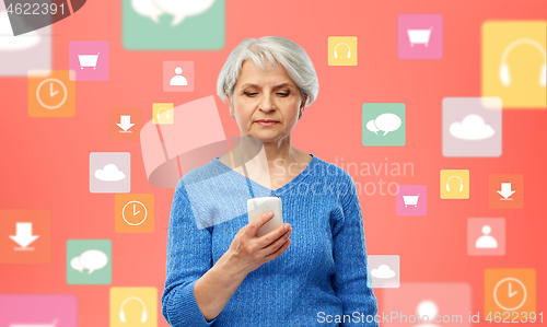 Image of senior woman with smartphone over mobile app icons