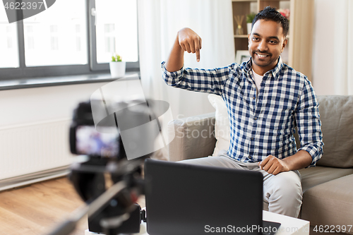 Image of male blogger with camera videoblogging at home