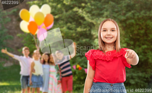 Image of smiling girl pointing to you at birthday party