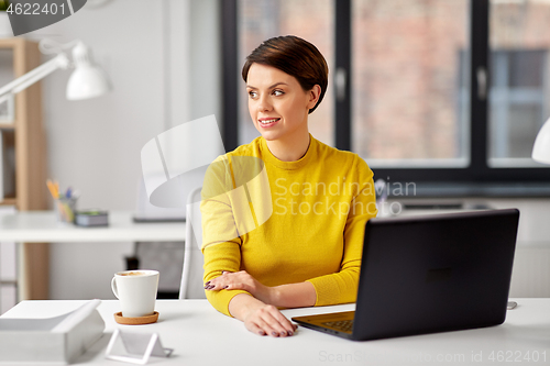 Image of businesswoman with laptop computer at office