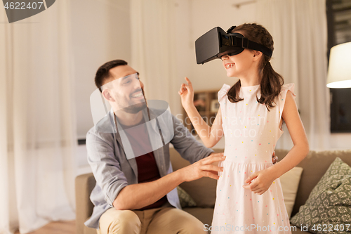 Image of father and daughter in vr glasses playing at home