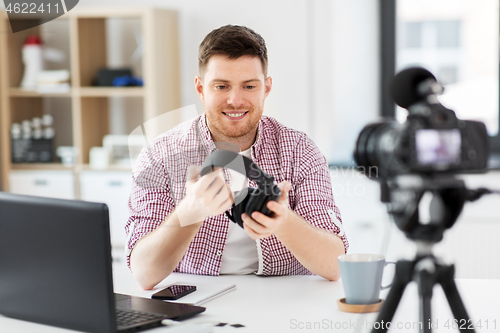 Image of male blogger with headphones videoblogging at home