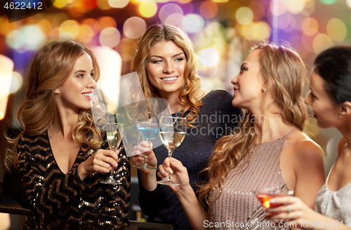 Image of happy women clinking glasses at night club