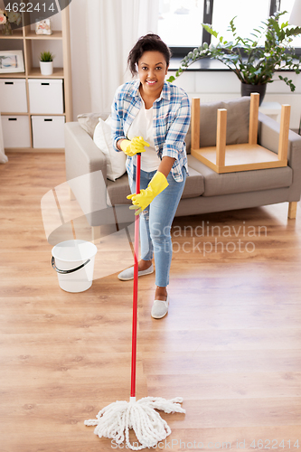 Image of african woman or housewife cleaning floor at home