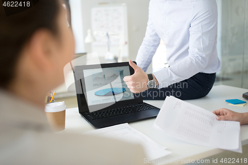 Image of businessman showing thumbs up at office