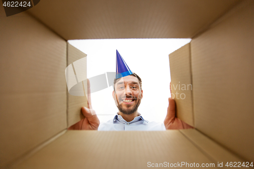 Image of happy man opening parcel box or birthday gift