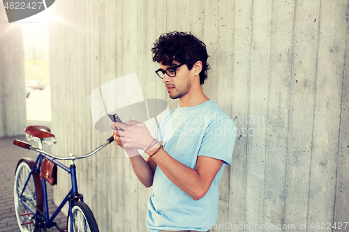 Image of man with smartphone and fixed gear bike on street