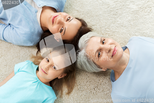 Image of mother, daughter and grandmother lying on floor