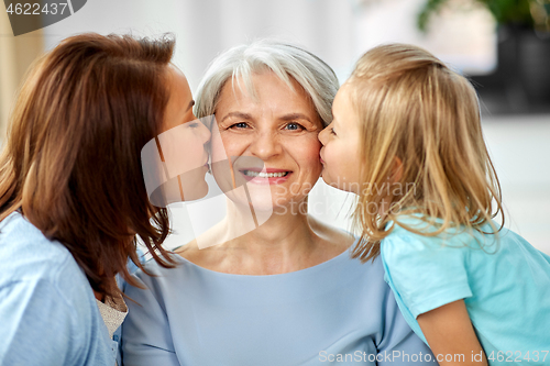 Image of mother and daughter kissing happy grandmother