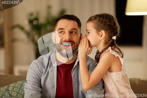 Image of happy daughter whispering secret to father at home