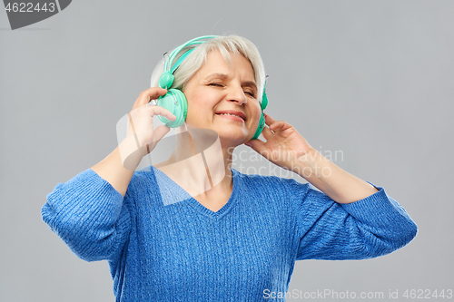 Image of senior woman in headphones listening to music