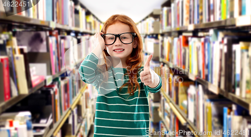 Image of smiling red haired girl in glasses at library