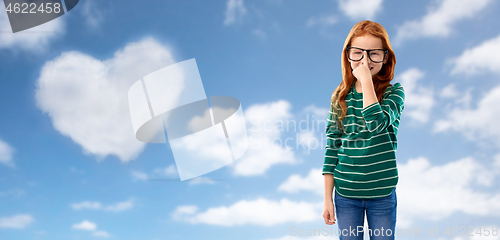 Image of cute red haired student girl in glasses over sky