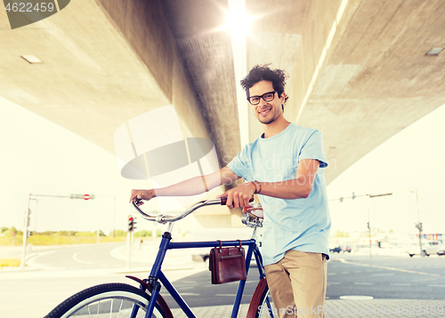 Image of hipster man with fixed gear bike under bridge