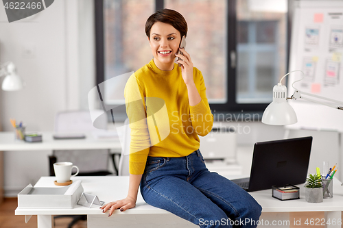 Image of businesswoman calling on smartphone at office