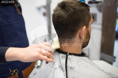 Image of male client and barber cleaning hair from neck