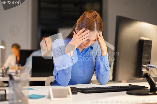 Image of businesswoman with computer at night office