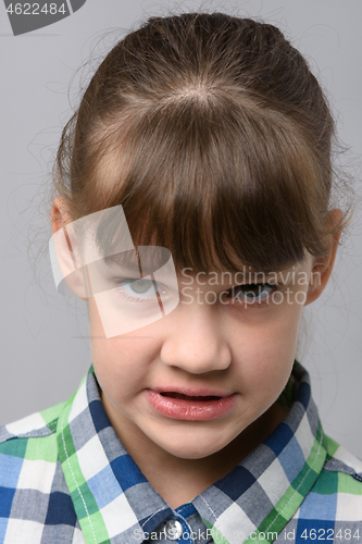 Image of Portrait of an angry grin ten-year-old girl of European appearance, close-up