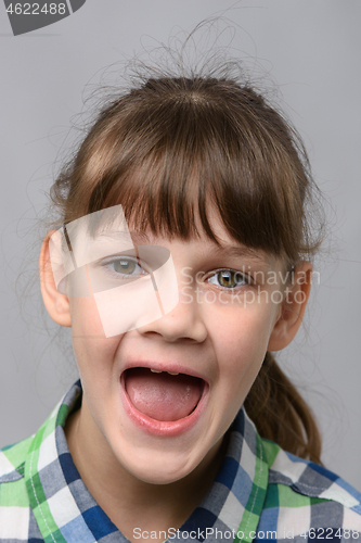 Image of Portrait of a happy ten year old girl with wide mouth, European appearance, close-up