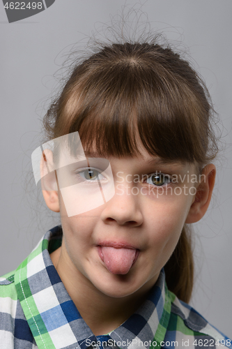 Image of Portrait of a ten-year-old girl showing tongue, European appearance, close-up