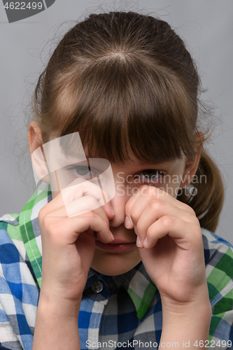 Image of Portrait of a crying ten-year-old girl of European appearance, close-up