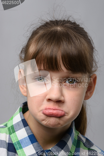 Image of Portrait of a displeased ten-year-old girl of European appearance, close-up
