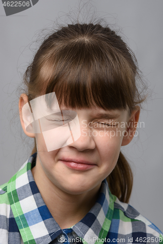 Image of Portrait of a ten-year-old girl who closed her eyes, European appearance, close-up