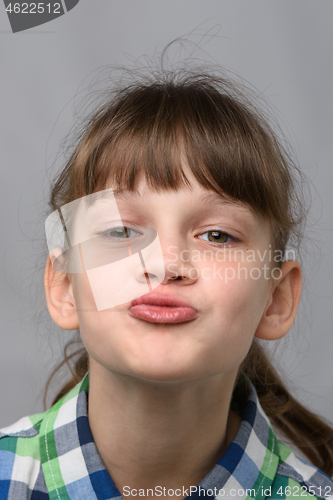 Image of Portrait of a ten-year-old girl showing a kiss, European appearance, close-up