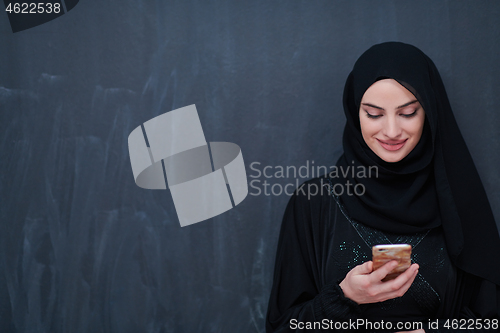 Image of young modern muslim business woman using smartphone