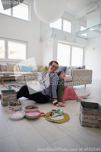 Image of Mother and little girl daughter playing with jewelry  at home