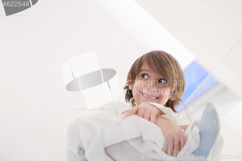 Image of portrait of little arabian boy sitting on the glass floor