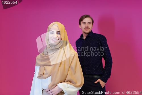 Image of portrait of young muslim couple isolated on pink background